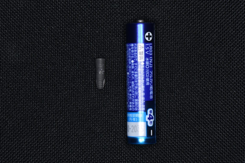 インプラント体と単4形乾電池の大きさ比較写真。インプラント体は乾電池よりはるかに小さい